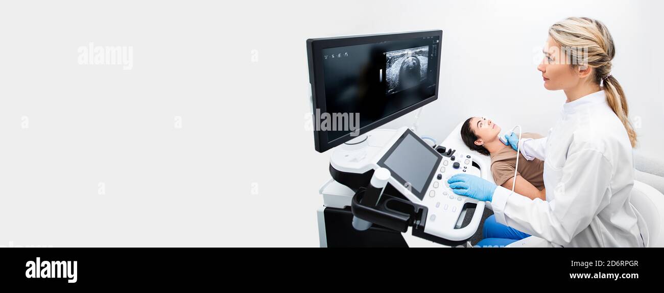 Ultraschalldiagnostik der Schilddrüse. Eine Endokrinologin, die einer Patientin in einem Ultraschallbüro eines modernen clin Ultraschalluntersuchungen anstellt Stockfoto