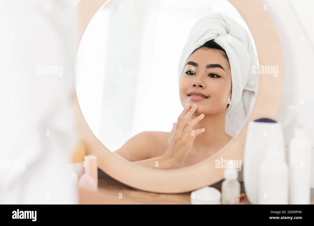 Schöne asiatische junge Frau Anwendung Gesichtscreme Stockfoto