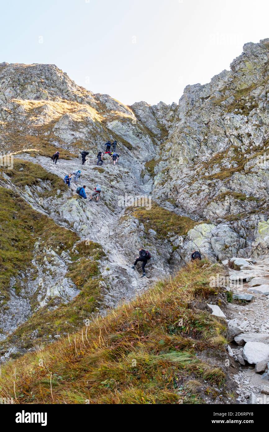 Tatra, Polen, 21/09/2020. Viele Touristen klettern steilen Weg mit Ketten in Richtung Szpiglasowa Pass in Tatra, Polen, Herbst. Stockfoto