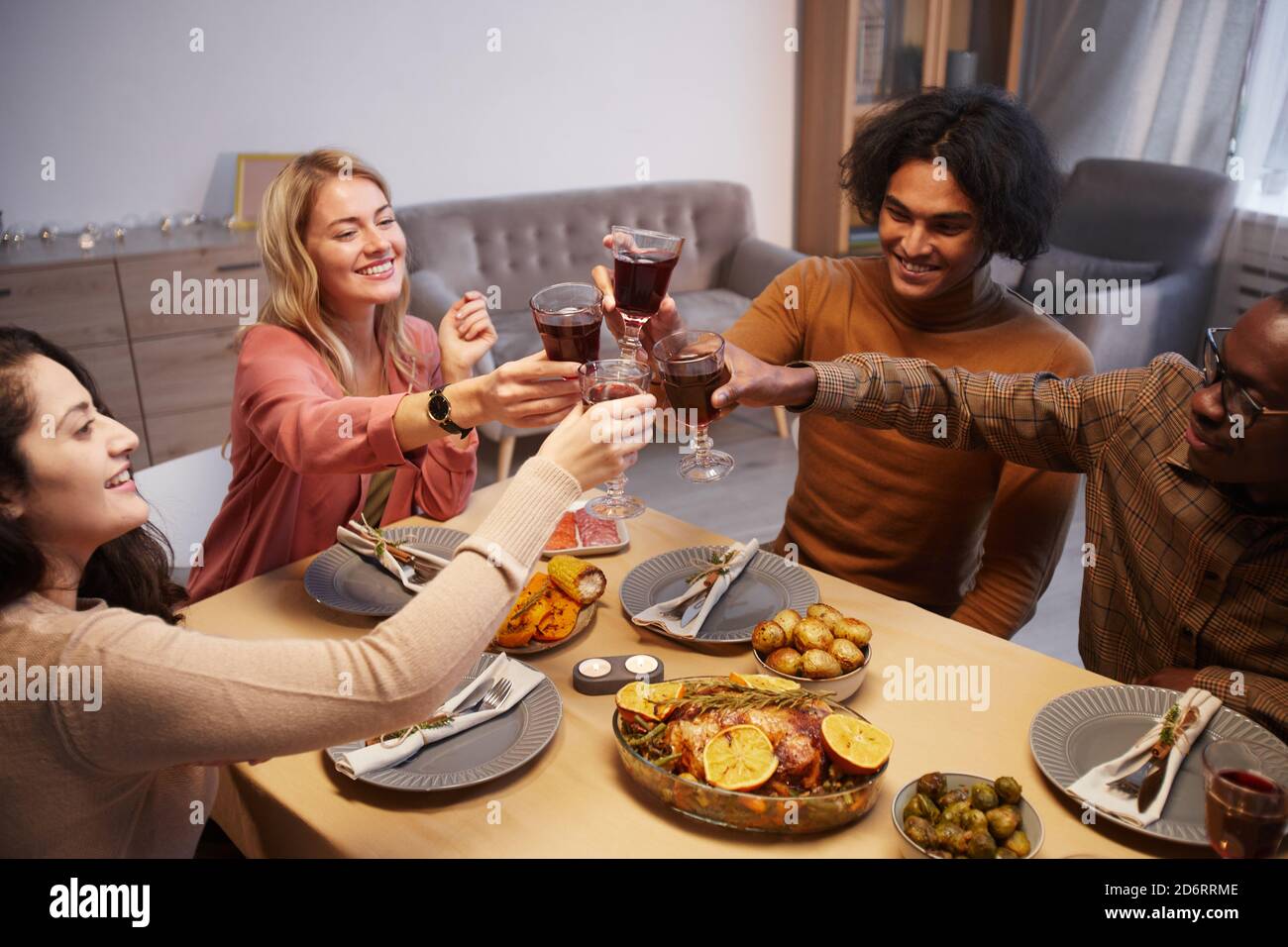 High-Angle-Ansicht auf multi ethnische Gruppe von glücklichen Menschen Toasting während genießen Abendessen Party mit Freunden und Familie Stockfoto