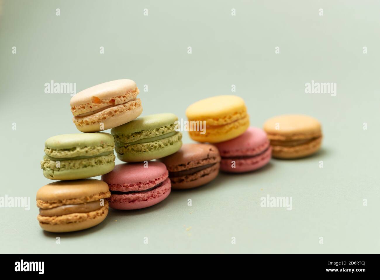 Stapel von bunten leckeren Makronen auf einem grünen Hintergrund. Stockfoto