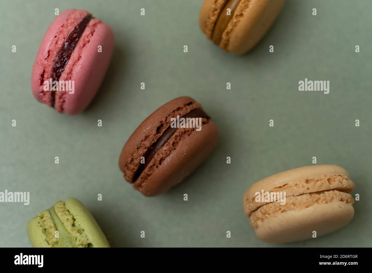 Verschiedene farbige leckere Makronen auf grünem Hintergrund. Stockfoto