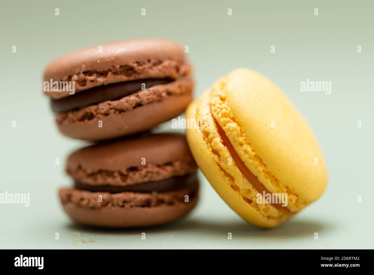 Stapel von bunten leckeren Makronen auf einem grünen Hintergrund. Stockfoto