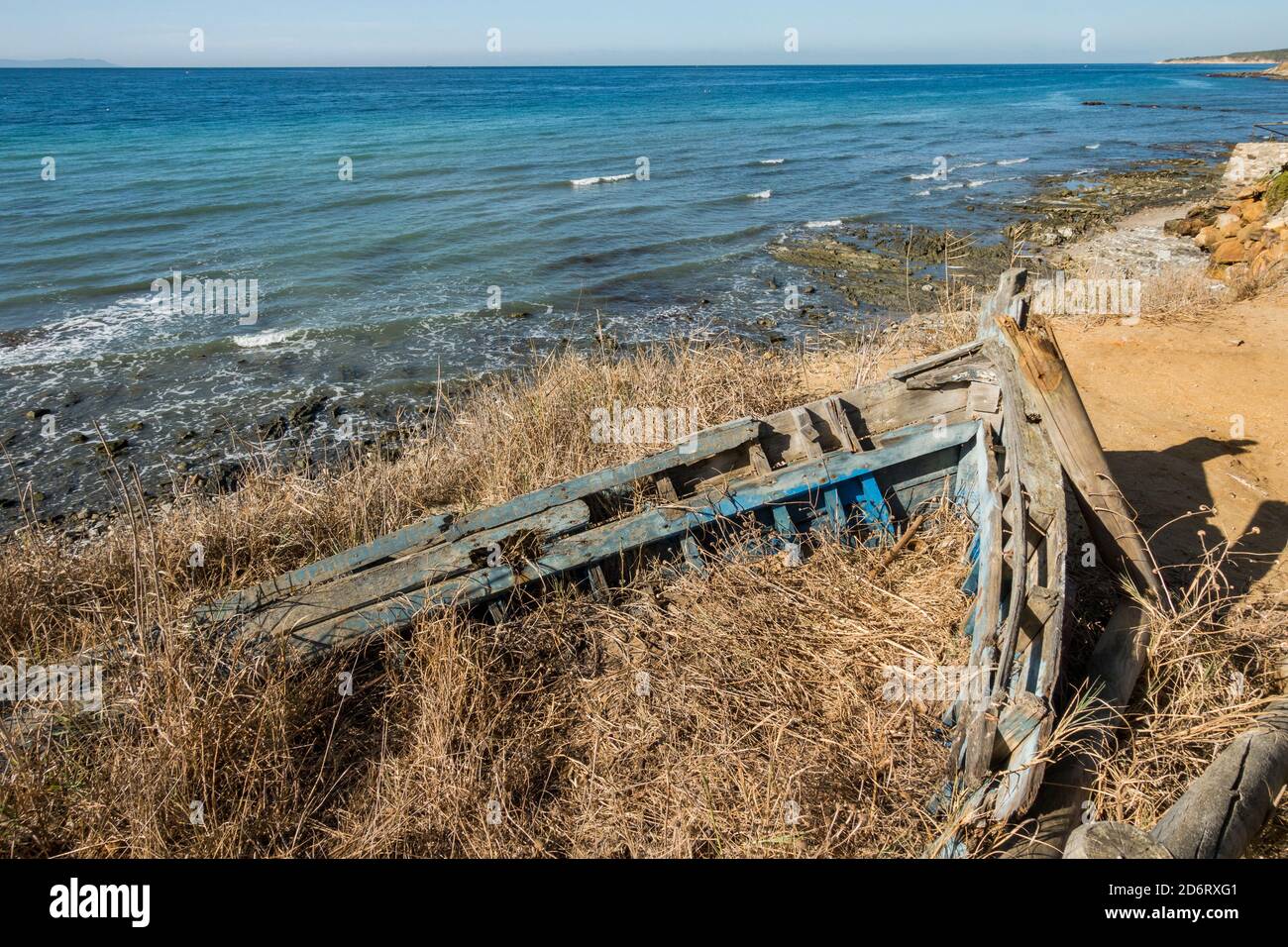 Überreste eines alten Holzbootes, das in den Sanddünen, Strand dahinter, Tarifa, Spanien, vergraben ist. Stockfoto