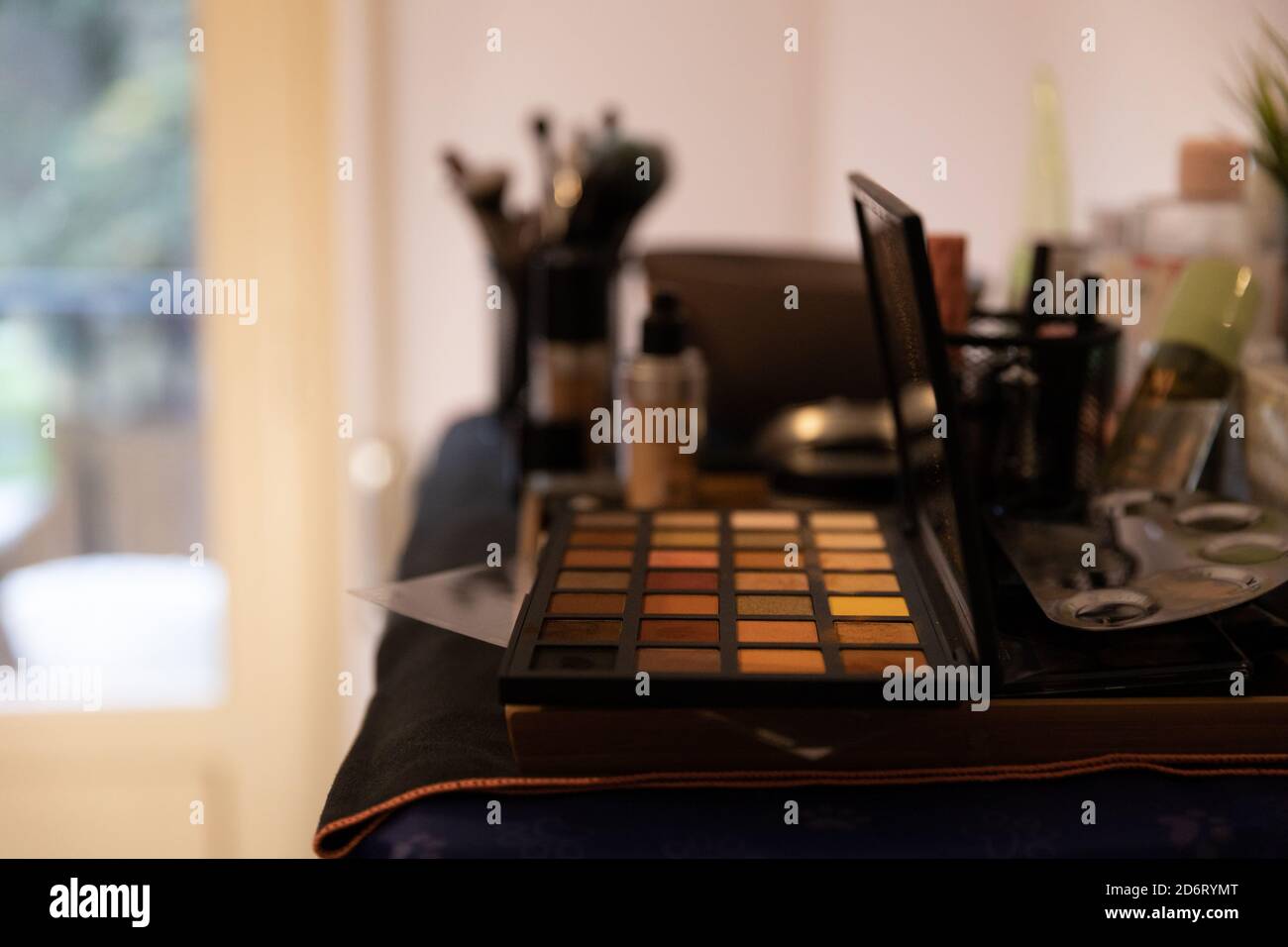 Sammlung von verschiedenen Make-up-Bürsten und Lidschatten Palette in platziert Halter auf dem Tisch im modernen Beauty-Studio Stockfoto