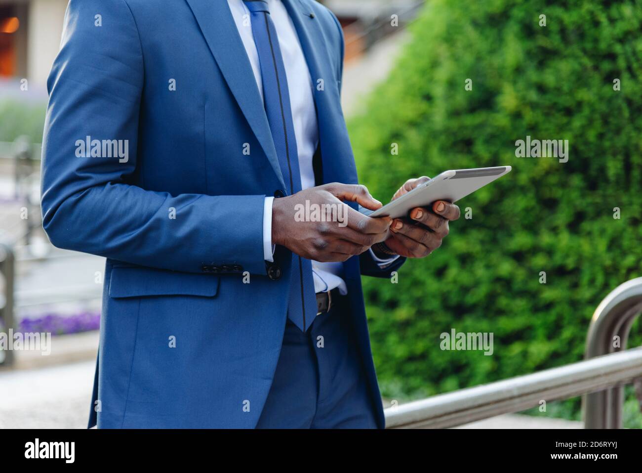 Crop Seitenansicht des zuversichtlich respektablen afroamerikanischen Geschäftsmann in Formelles Outfit, das sich auf der Straße an modernen Gebäuden anlehnt Downt Stockfoto