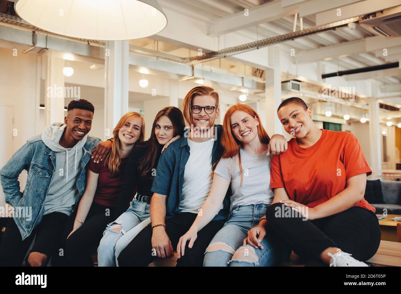 Portrait einer multiethnischen Gruppe von Studenten, die auf dem Campus sitzen. Schülerinnen und Schüler zusammen. Stockfoto