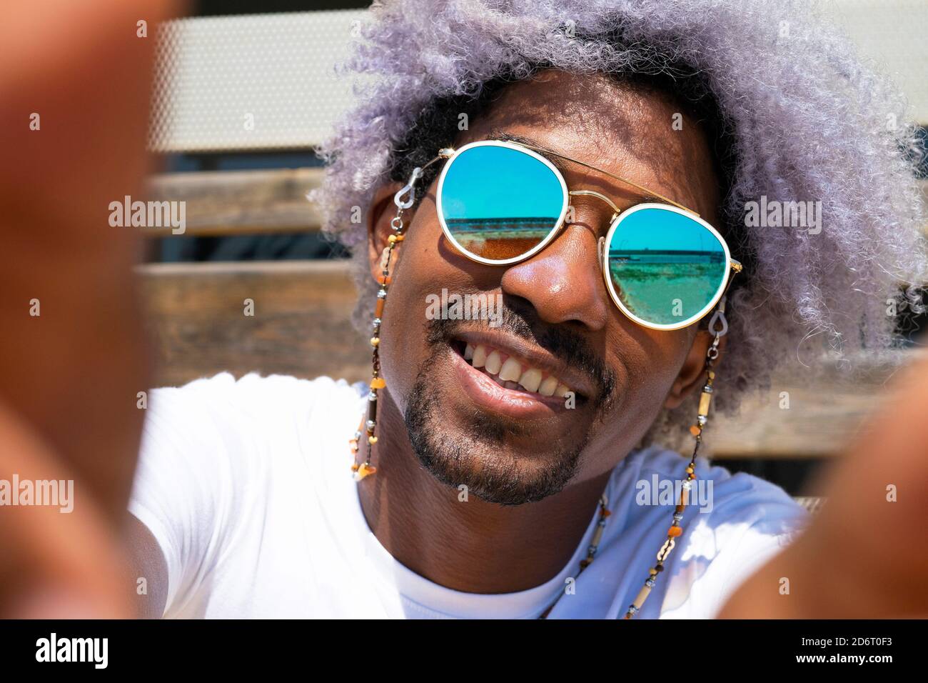 Schwarzer Mann mit afro Haar lächelnd und ein Selfie. Schwarzer Mann nimmt ein Selfie. Stockfoto