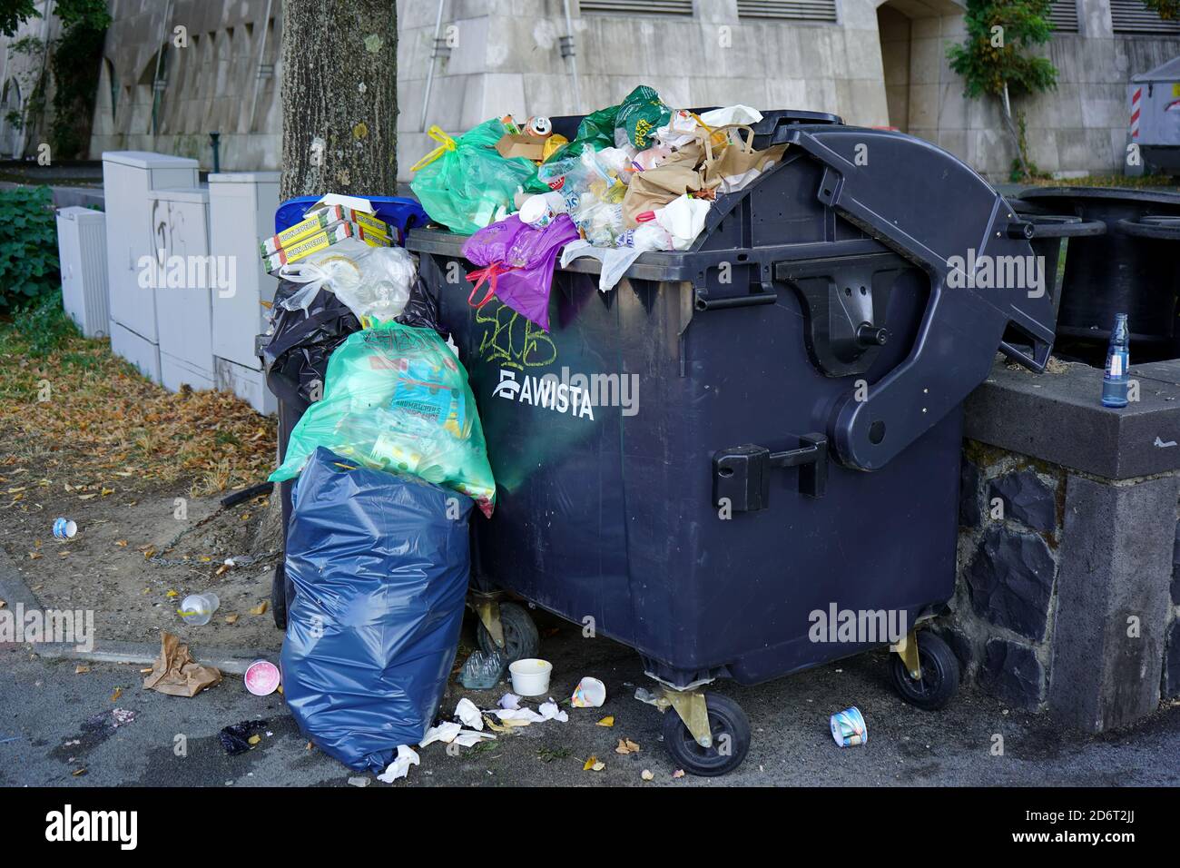 Unordentlicher Mülleimer mit Mülltüten und vereinzelten Müll. Stockfoto