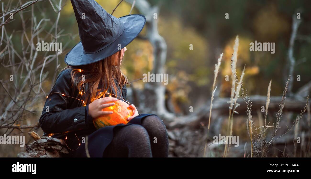 Nettes Mädchen in einem Halloween Kostüm mit einer Taschenlampe. Stockfoto