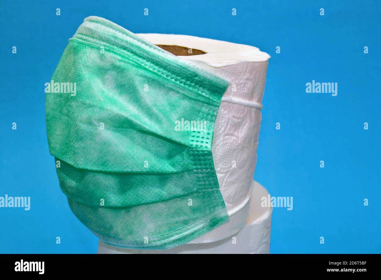 Die beiden am meisten diskutierten Objekte im Jahr 2020: Maske und Toilettenpapier. Ein Foto enthält grüne medizinische Maske und weißes Toilettenpapier. Stockfoto