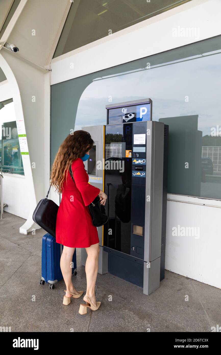 Seitenansicht der weiblichen Touristen, die Tickets von der Selbstbedienung bekommen Maschine vor dem Flug im Flughafen Stockfoto