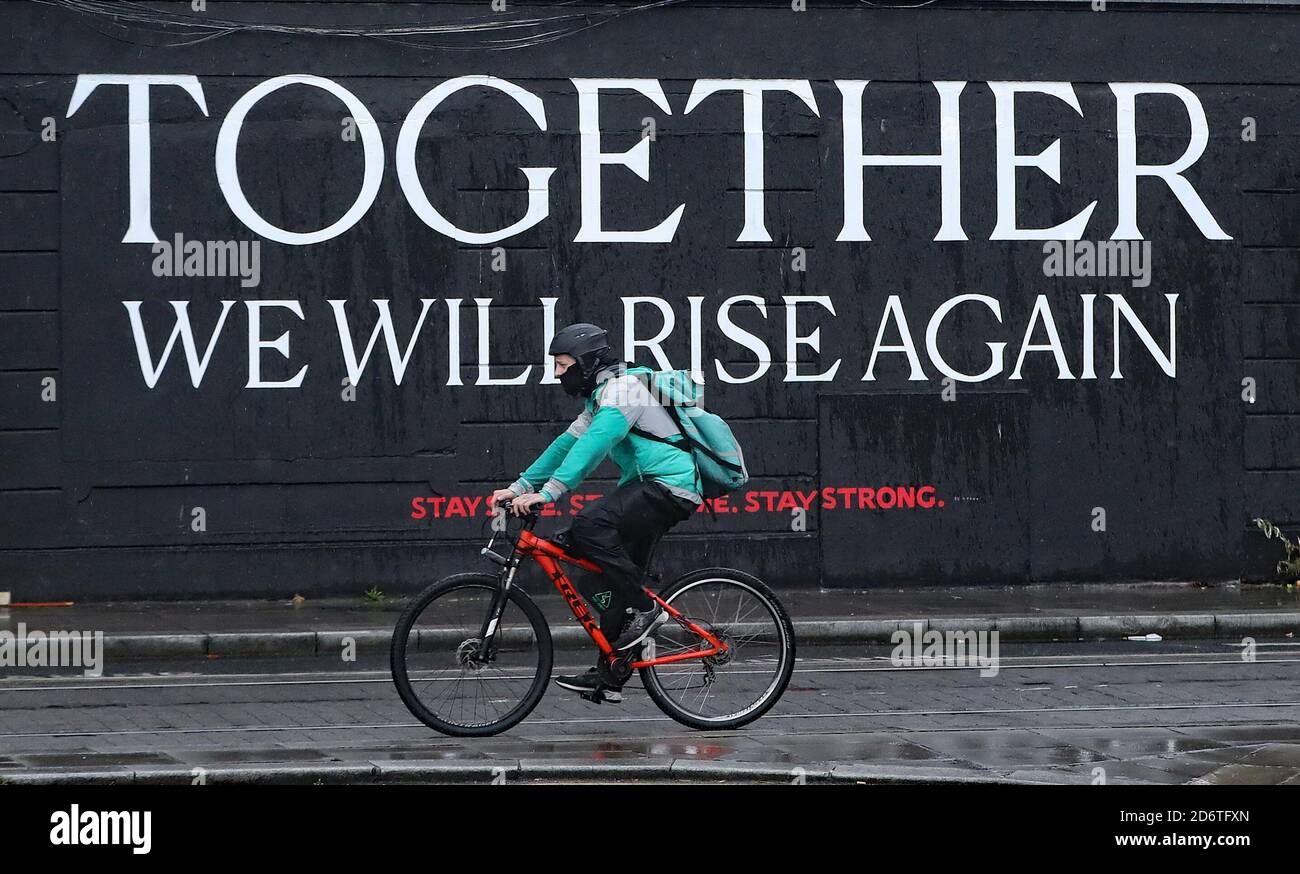 Ein Radfahrer passiert ein Wandgemälde im Stadtzentrum von Dublin, da die irische Regierung voraussichtlich Pläne zur Einführung weiterer landesweiter Beschränkungen hinsichtlich der steigenden Zahl von Coronavirus-Fällen abzeichnen wird. Stockfoto