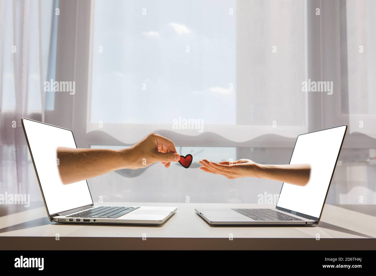 Online-Dating-Konzept zwei Hände Stick aus Laptop-Bildschirm Stockfoto