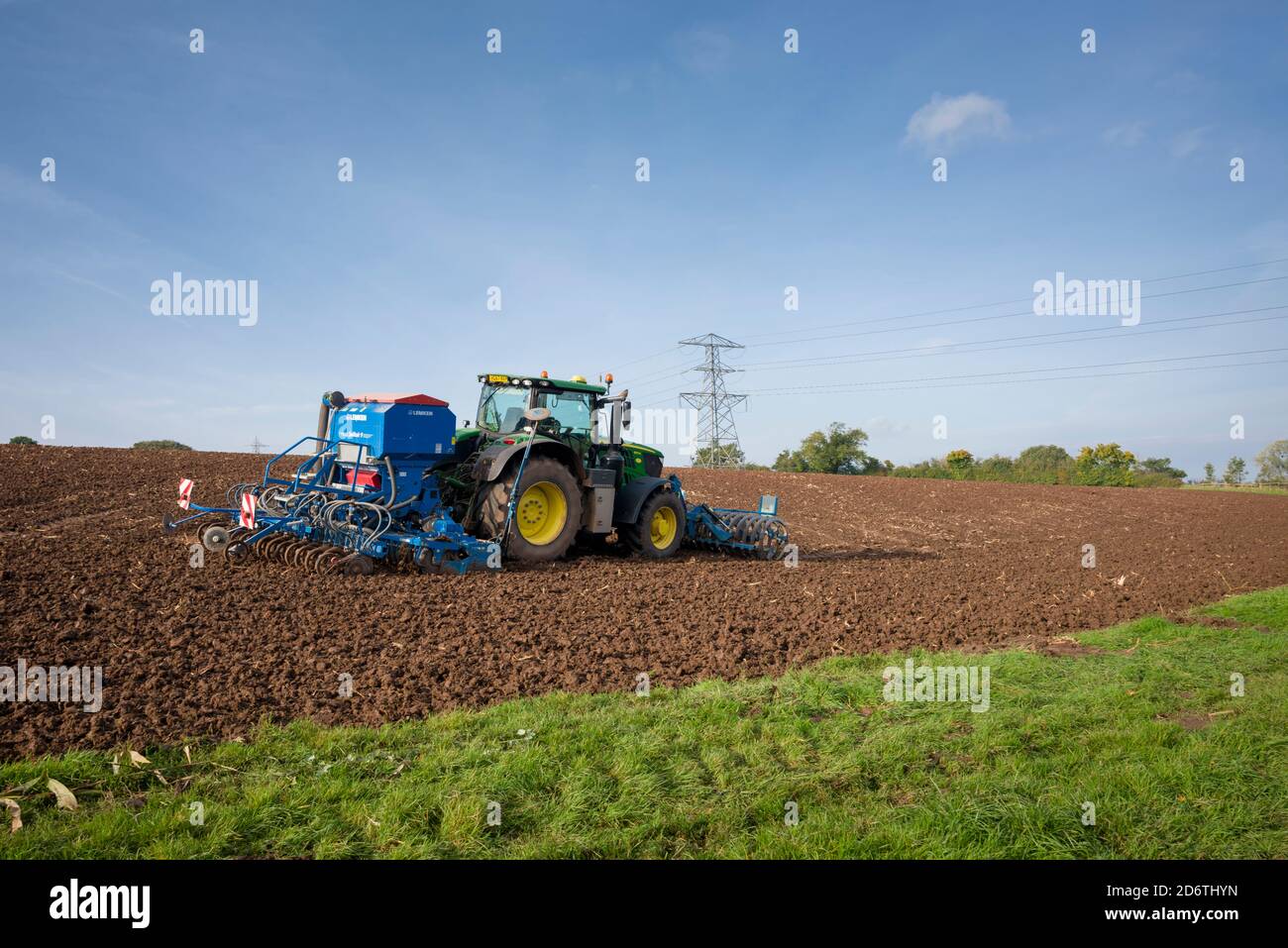 Ein John Deere Traktor 6175R, der mit einer pneumatischen Sämaschine Lemken Solitair 9 Samen auf einem frisch gepflügten Feld aussaat. Wrington, North Somerset, England. Stockfoto