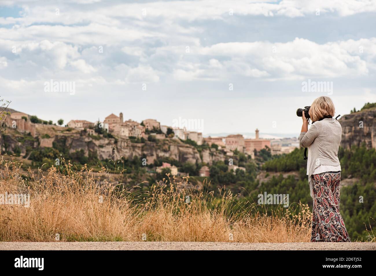 Seitenansicht der unkenntlich reifen Fotografin mit professionellem Foto Kamera fotografiert die Altstadt Cuenca mit mittelalterlichen Gebäuden Auf Hi Stockfoto