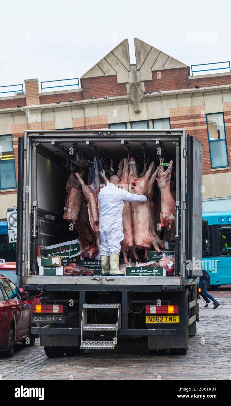 Ein Mann, der die Fleischkadaver auf der Rückseite des Fleischlieferwagens in East Row, Darlington, England, UK, aussortierte Stockfoto