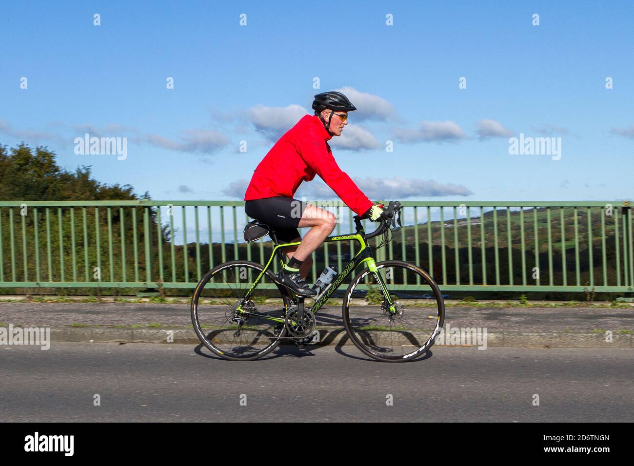 Männlicher Radfahrer auf Cannondale Carbon Leichtbau Sport Rennrad auf dem Land Route überqueren Autobahnbrücke in ländlichen Lancashire, Großbritannien Stockfoto