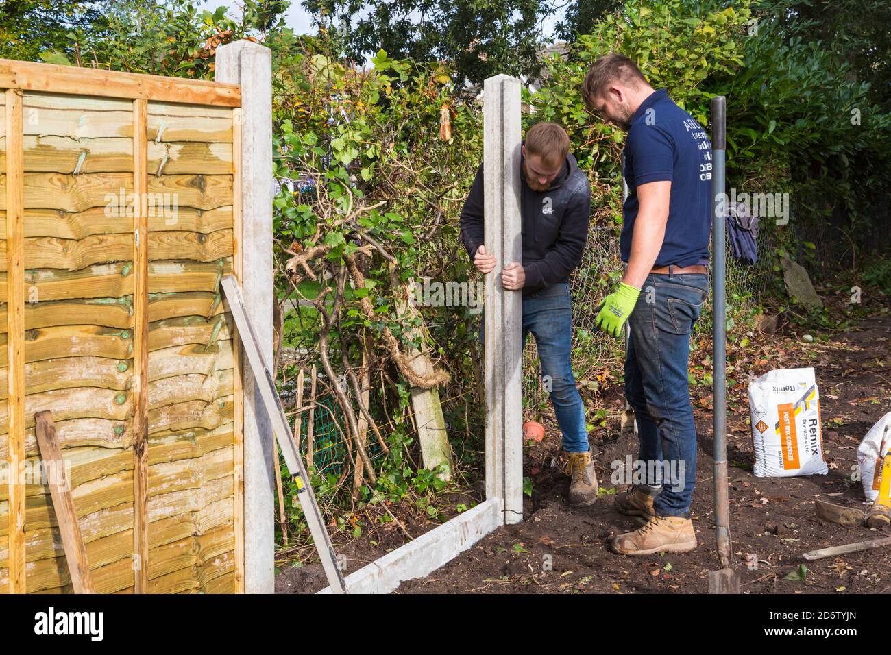 Gartenarbeit und Renovierung Teilnahme an Garten in Bournemouth, Dorset UK im Oktober - Errichtung der Installation neuer Zäune, Zaunpfosten Stockfoto