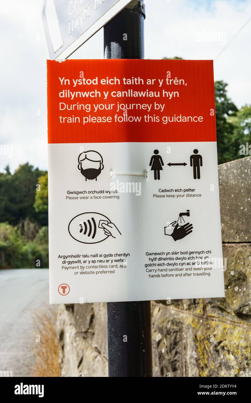Transport für Wales Coronavirus Hinweis vor Chirk Bahnhof in Englische und walisische Sprache, in der Passagiere über Coronavirus-Maßnahmen informiert werden Stockfoto