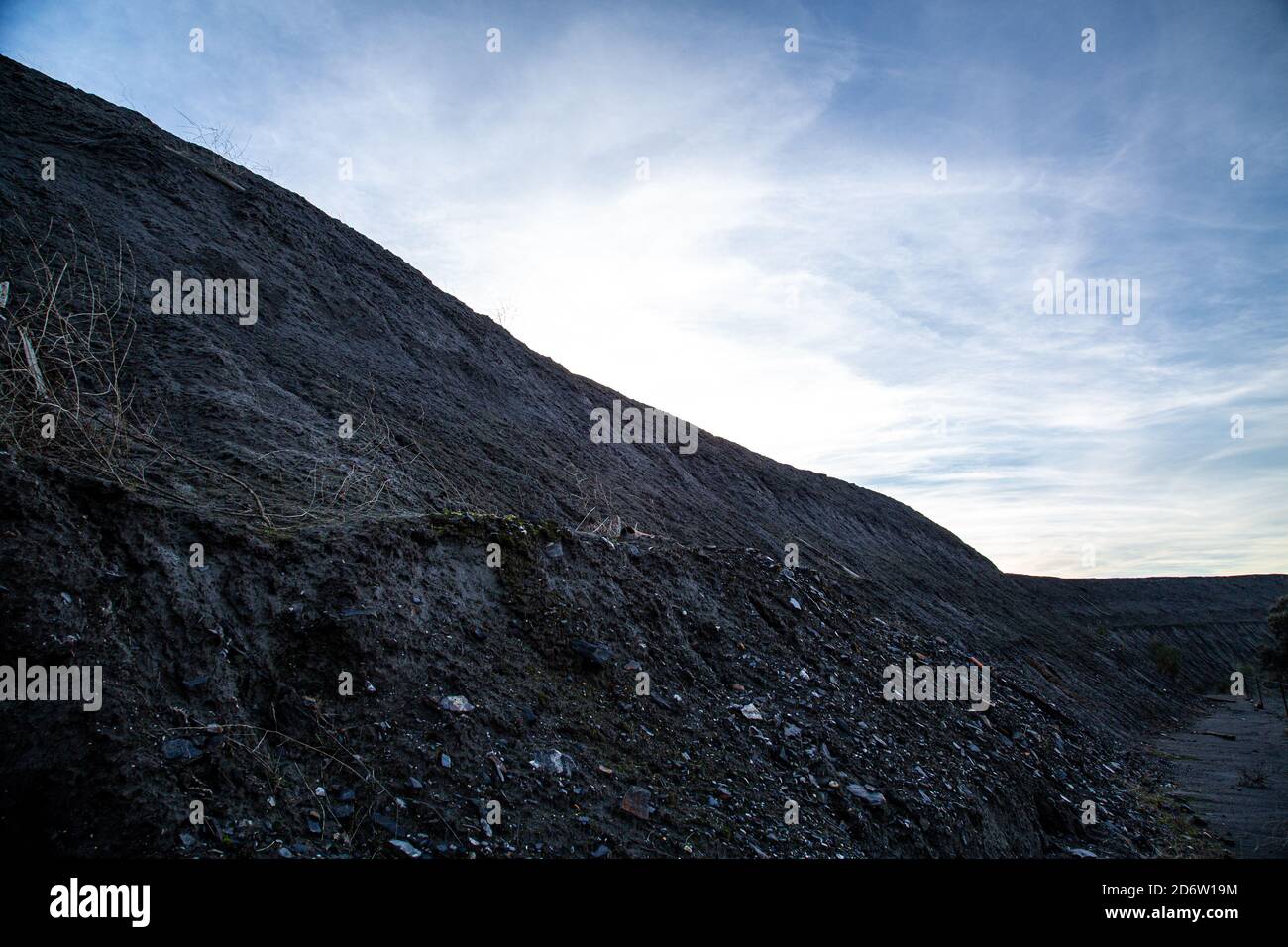 Deponieberg mit blauem Himmel und verschwommenen Wolken Stockfoto