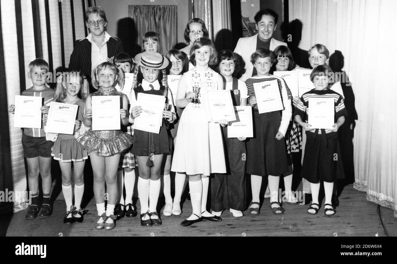 Butlins Filey, North Yorkshire, England, Großbritannien. 1975-1977 Archivbilder von Urlaubern & Rotkittern bei Butlins Filey. Ein Kinderanimateur hinter der Bühne mit Gewinnern eines Talentwettbewerbs Stockfoto