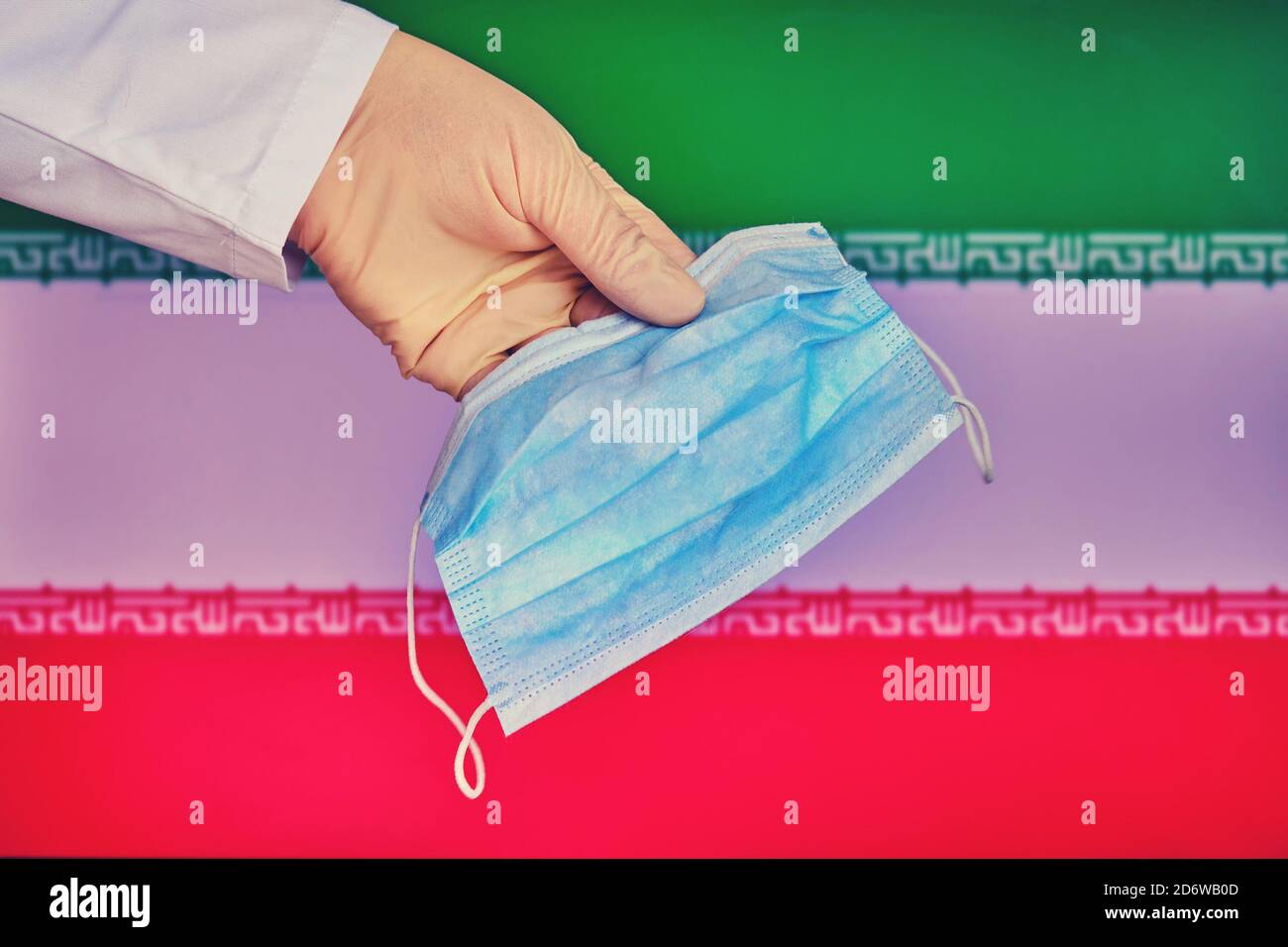 Medizinische Maske in den Händen eines Arztes und der Iran-Flagge, Kopierraum. Schutzhandschuh mit Maske Nahaufnahme auf dem Hintergrund des Staates iranischen Symbol Stockfoto