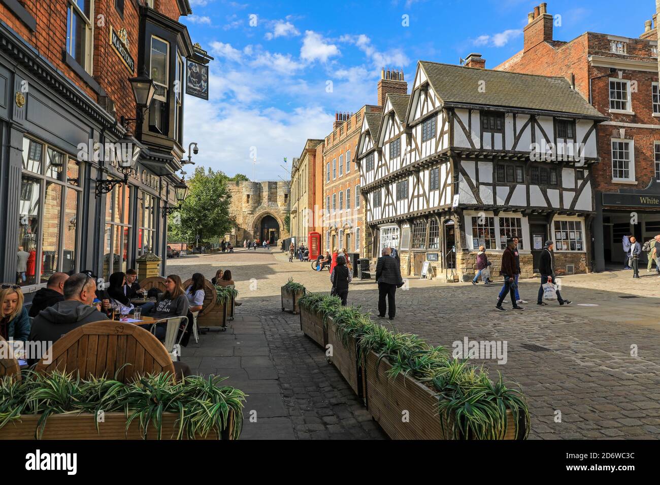 Menschen, die in einem Café im Freien neben dem Magna Carta Pub, Exchecr Gate, Baligate und Castle Hill, City of Lincoln, Lincolnshire, England, Großbritannien, sitzen Stockfoto