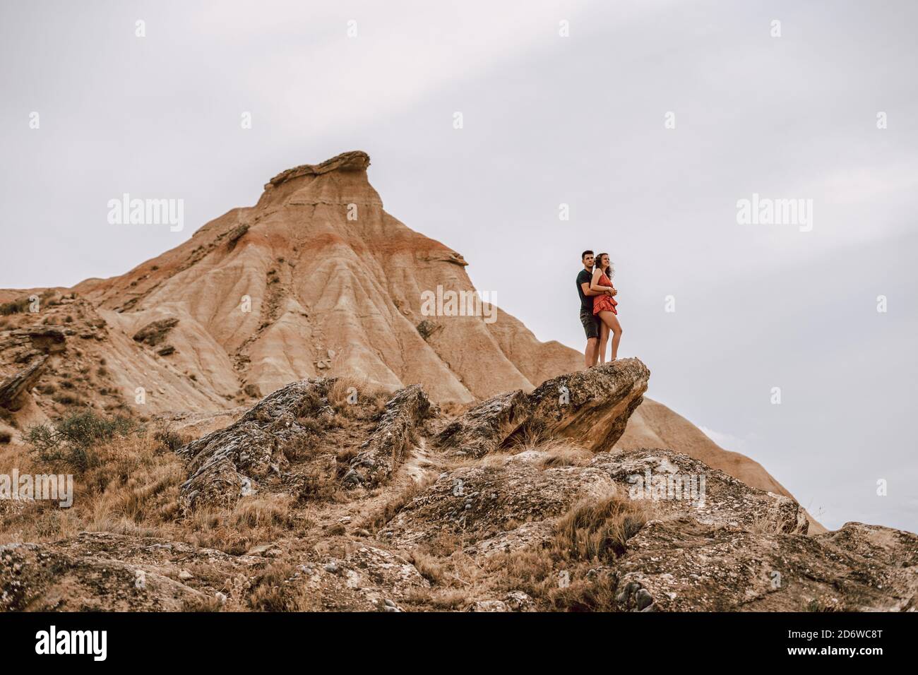 Paar auf einem Felsen in einer desertischen Landschaft in der Barcenas Reales Wüste in Navarra, Spanien Stockfoto
