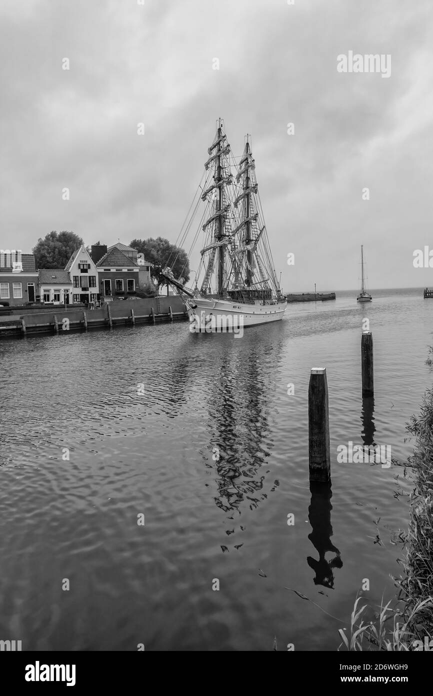 Schwarz-weißes Bild eines Segelschiffs, das in den einfährt Stadt Medemblik in der Provinz Nordholland Stockfoto