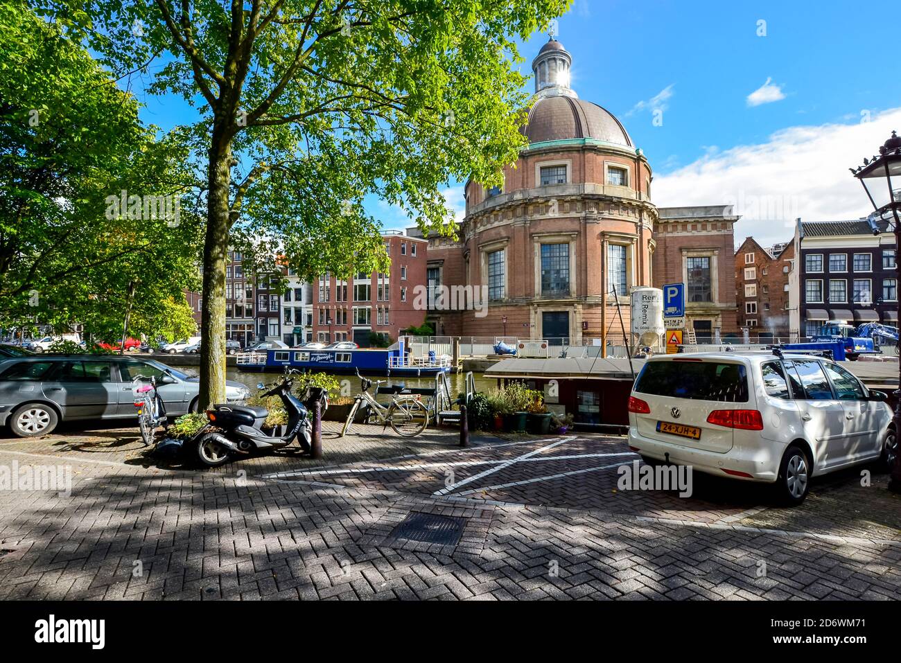 Das schwimmende Katzenhaus oder catboat, das Poezenboot an einem Innenkanal im Zentrum von Amsterdam mit der runden lutherischen Kirche im Blick hinter Stockfoto