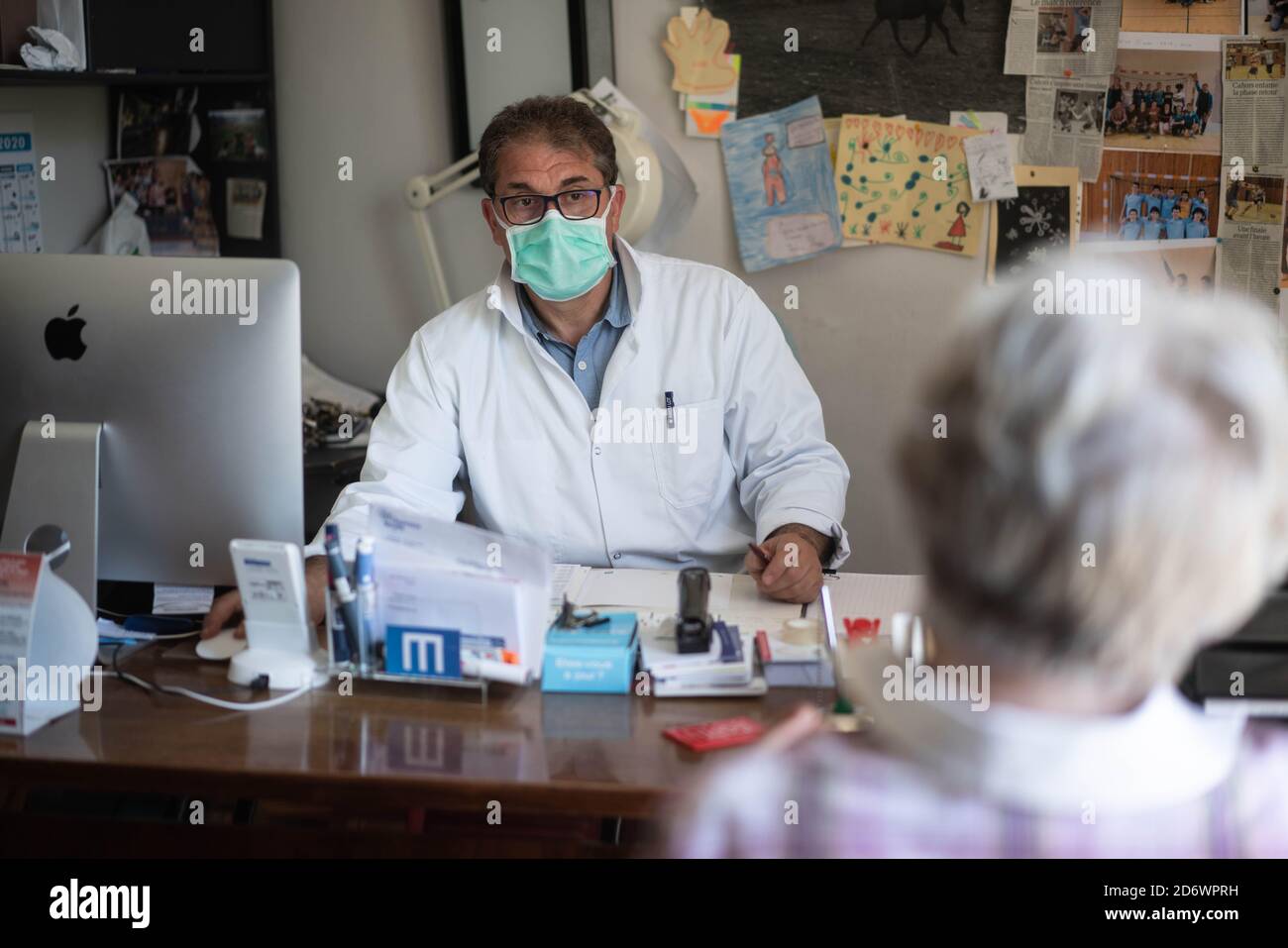 Frau in Absprache mit einem Hausarzt mit einer OP-Maske, Frankreich, Mai 2020. Stockfoto