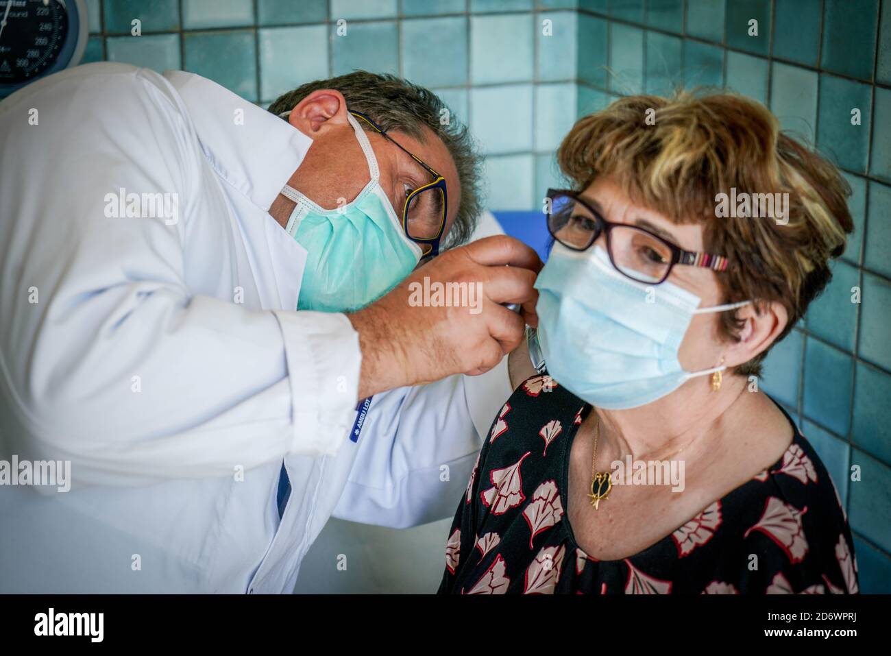 Frau in Absprache mit einem Hausarzt mit einer OP-Maske, Frankreich, Mai 2020. Stockfoto