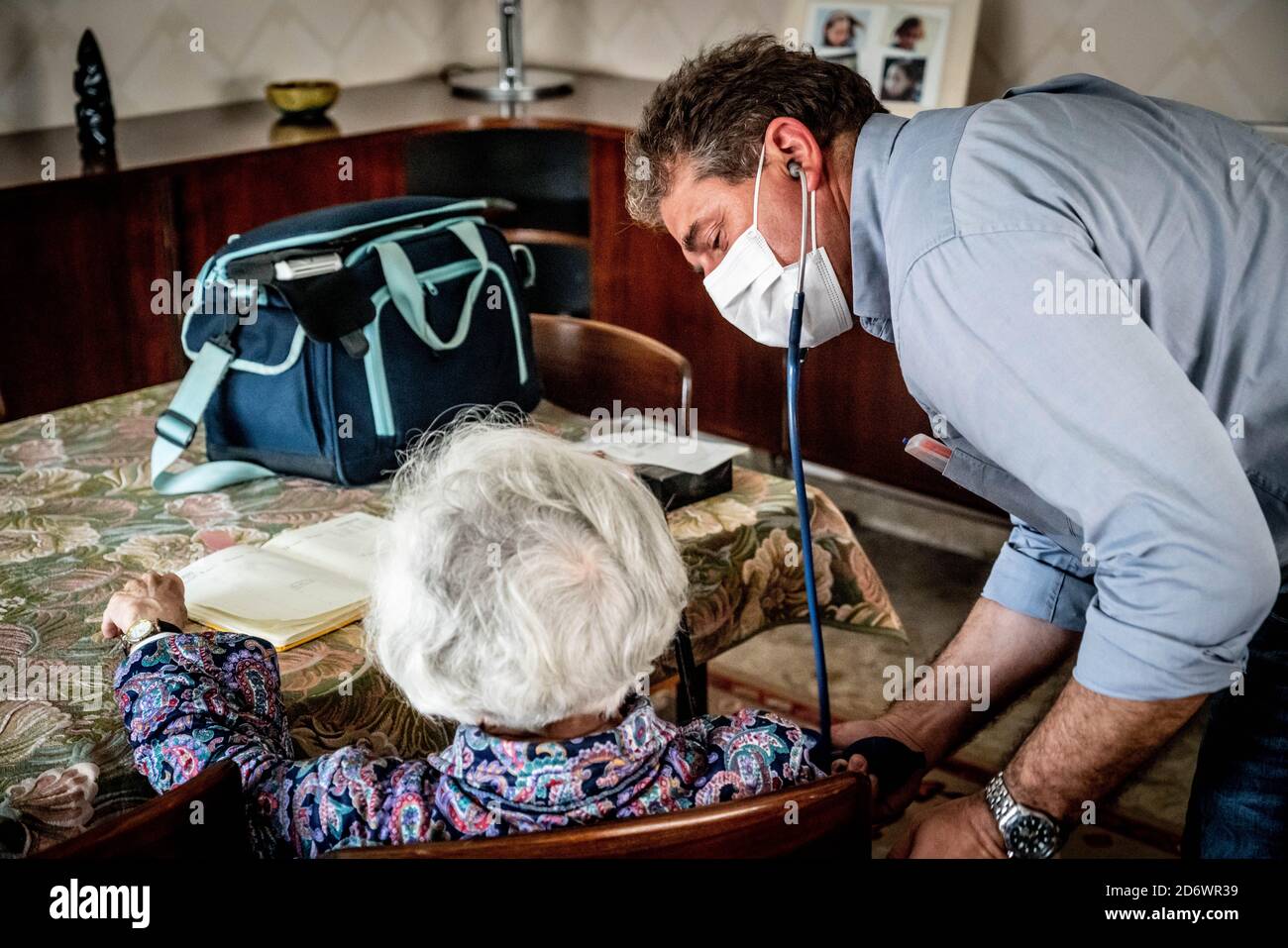 Hausarzt mit OP-Maske, mit Patient zu Hause, Frankreich, juni 2020. Stockfoto