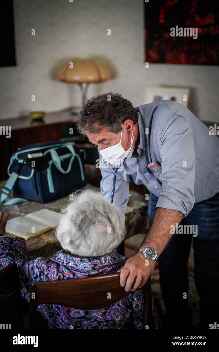 Hausarzt mit OP-Maske, mit Patient zu Hause, Frankreich, juni 2020. Stockfoto