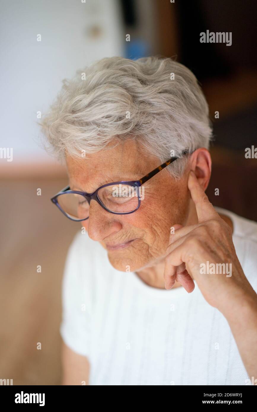 Frau berührt ihren Kopf und Ohr mit Ohrenschmerzen. Stockfoto