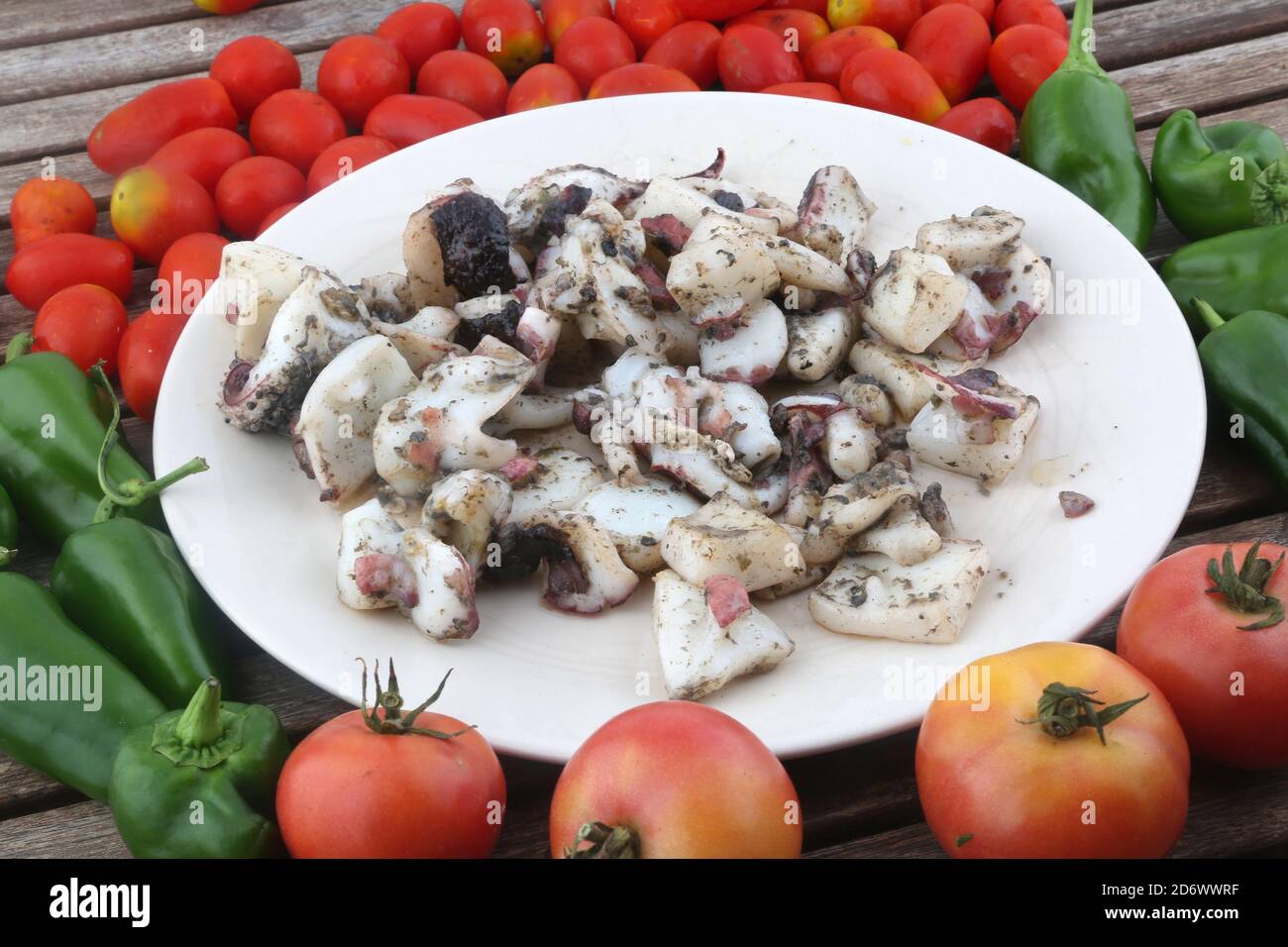 Gekochte Krake Tentakeln als Meeresfrüchte mit Tomaten und Paprika Hintergrund Stockfoto