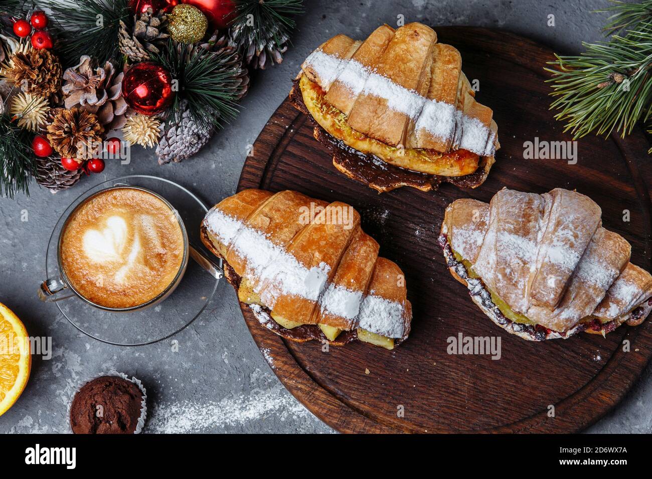 Neujahrsfrühstück mit Croissants. Set von drei Neujahrscroissants. Neujahrs-Croissants mit karamellisierter Banane, Orange und Ananas Stockfoto