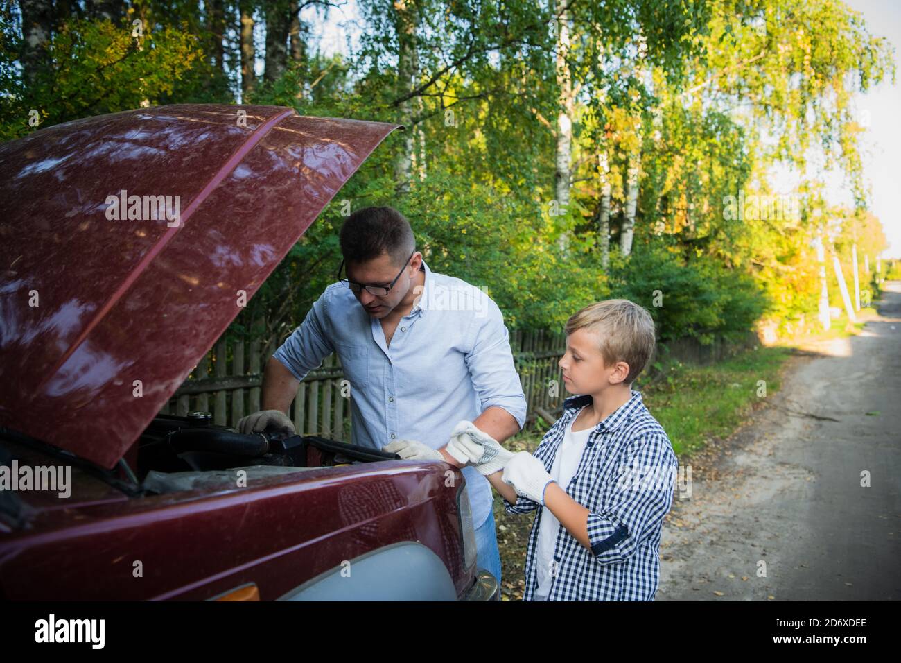 Papa und sein Sohn Reparatur Auto mit offener Haube im Freien, Befestigung Motor Stockfoto