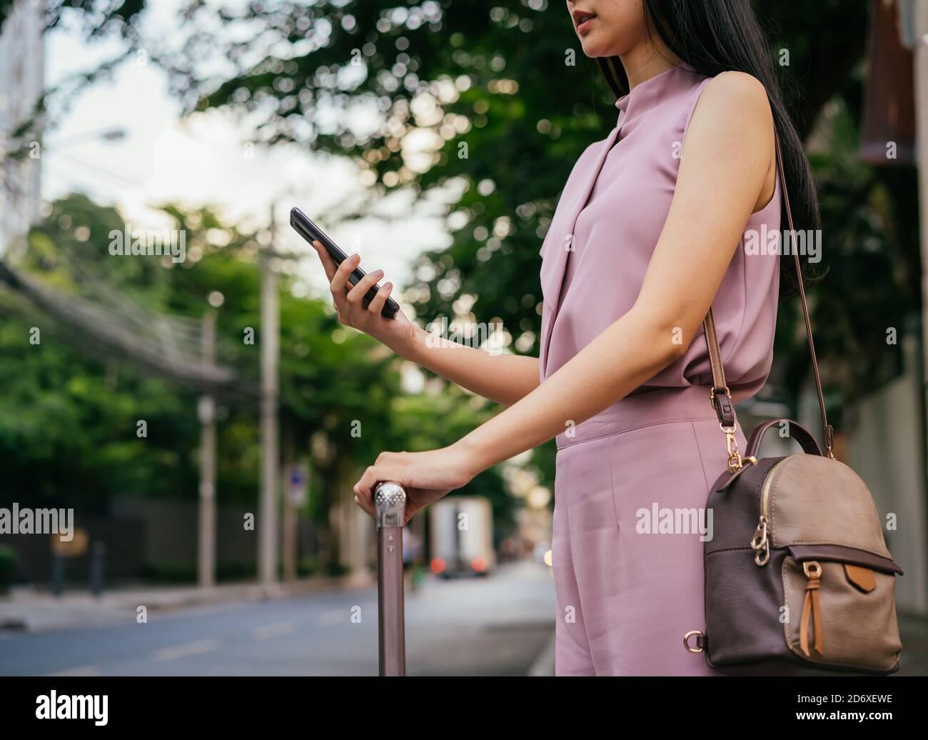 Geschäftsfrau unterwegs mit Smartphone, per App Taxi buchen, Kommunikation, Verbindung, unterwegs, Geschäftsreisen Stockfoto