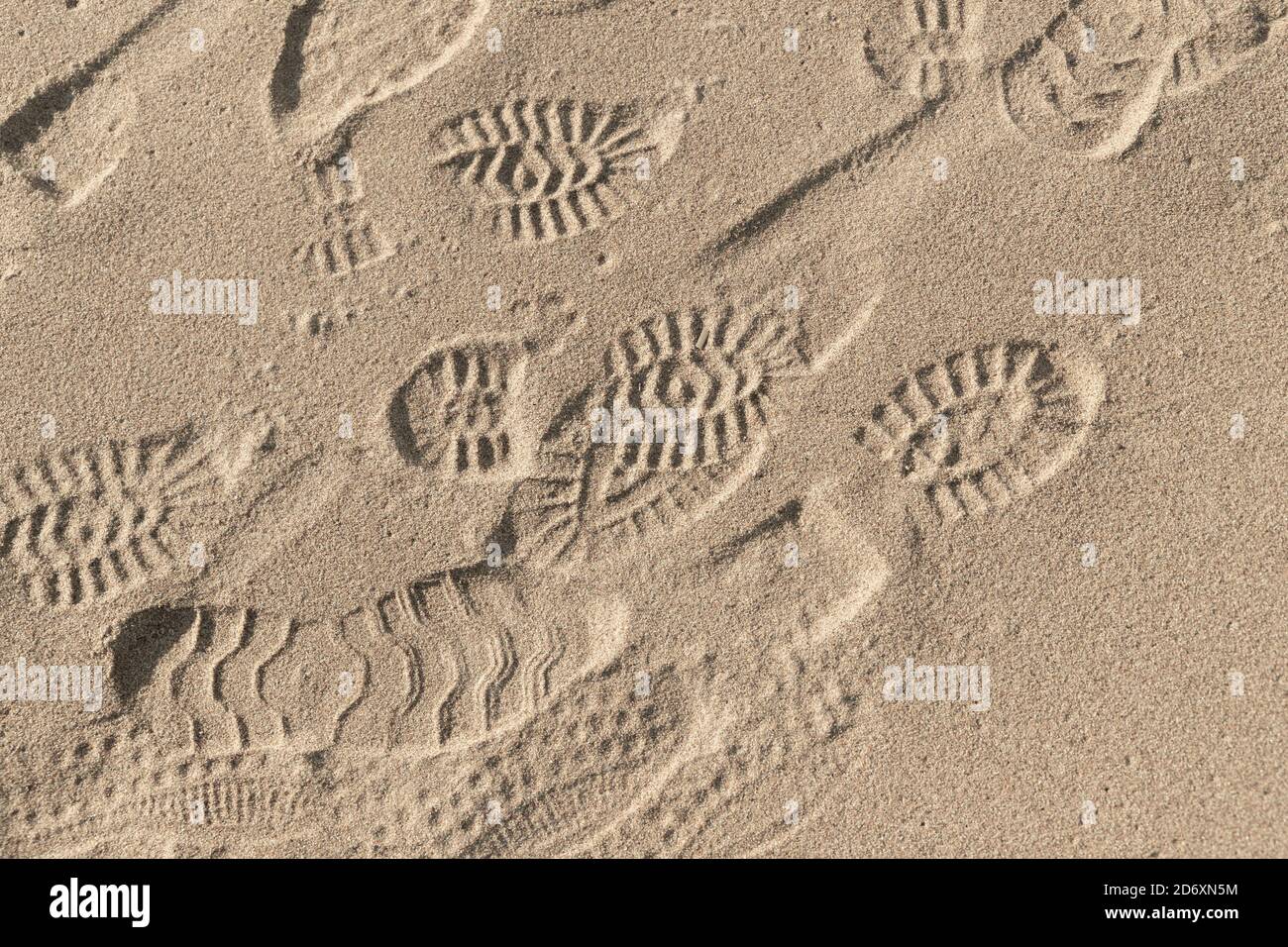 Fußabdrücke in nassem Sand am Strand, Hintergrundfotostruktur, Draufsicht Stockfoto