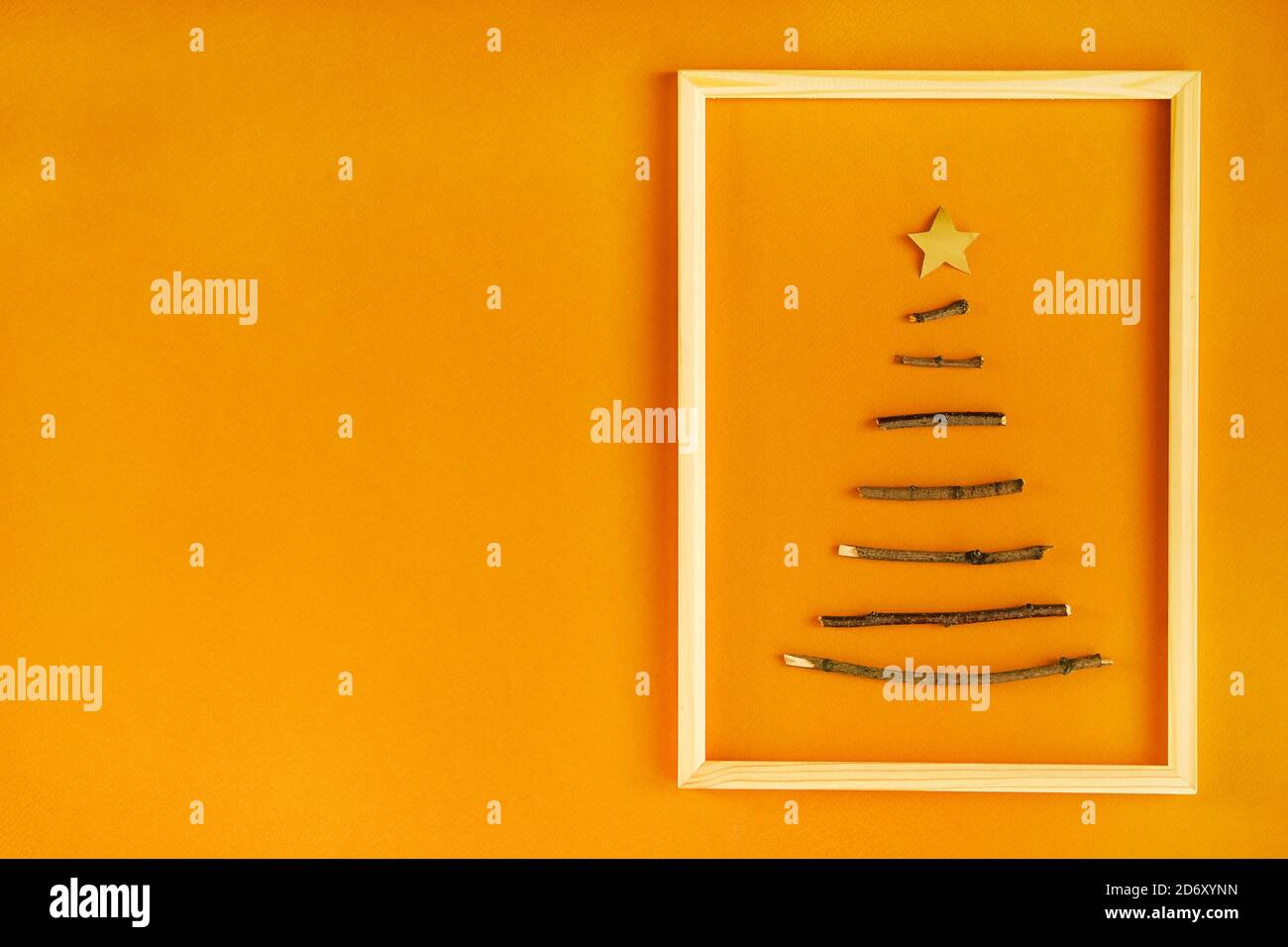 Kreativer nachhaltiger Weihnachtsbaum aus Holzstäben. Minimales DIY-Design auf Bastelpapier Hintergrund mit Kopierplatz. Kein natürliches Kunststoffdesign. Stockfoto