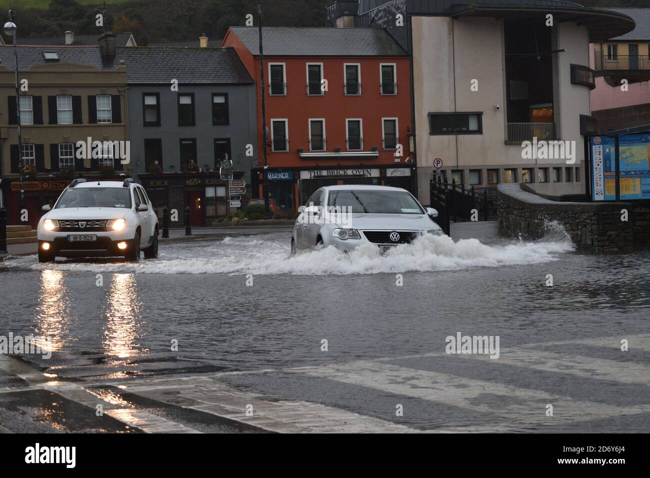 Fahrzeuge, die durch das Wasser der Überschwemmungen auf dem Wolfe Tone Square, Bantry Stadtlots, West Cork, Irland, fahren Stockfoto