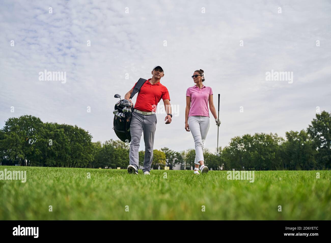 Erfreut Golfspielerin starrte auf ihren Golflehrer Stockfoto