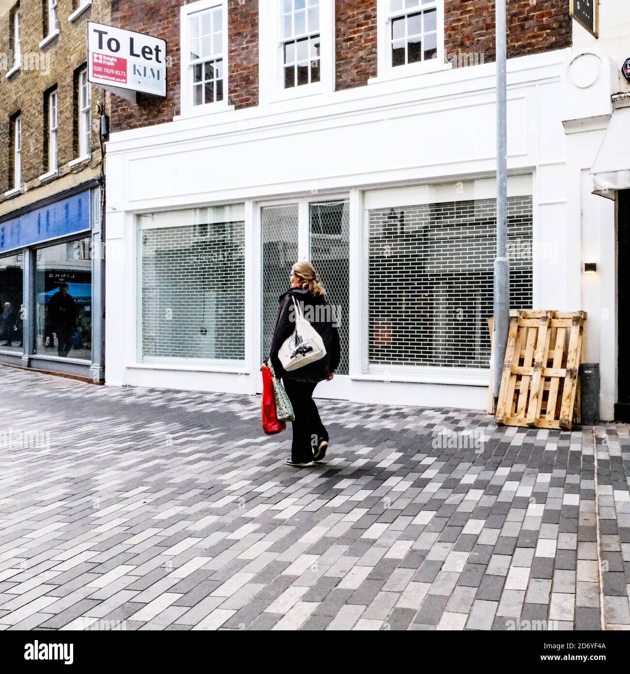 London, Großbritannien, Oktober 19 2020, Single Anonymous Woman, der während der COVID-19 an EINEM geschlossenen High Street Retail Business Shop vorbeiläuft Stockfoto