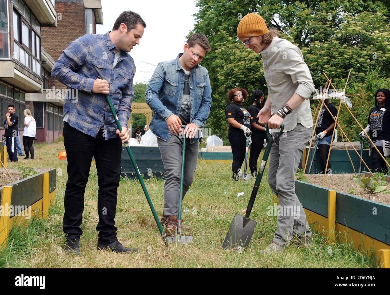 Scouting for Girls helfen bei einem Orange RockCorps Projekt in Lambeth, Süd-London, als Teil eines Projekts, um Freiwillige für Community-Projekte im Gegenzug für Konzertkarten zu ermutigen. Stockfoto