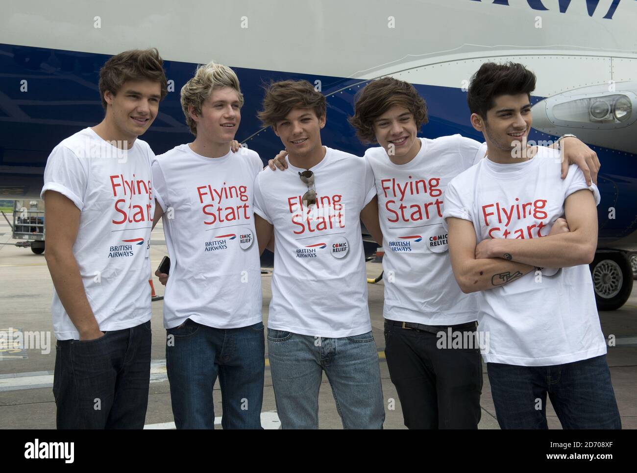 Eine Richtung (l-r Liam Payne, Niall Horan, Louis Tomlinson, Harry Styles und Zayn Malik) im Bild neben Flug BA1D - ein privater Charterflug von London nach Manchester, veranstaltet von der Band für Wettbewerbssieger, die Â£50,000 für Flying Start - British Airways Wohltätigkeitsorganisation mit Comic Relief gesammelt. Stockfoto