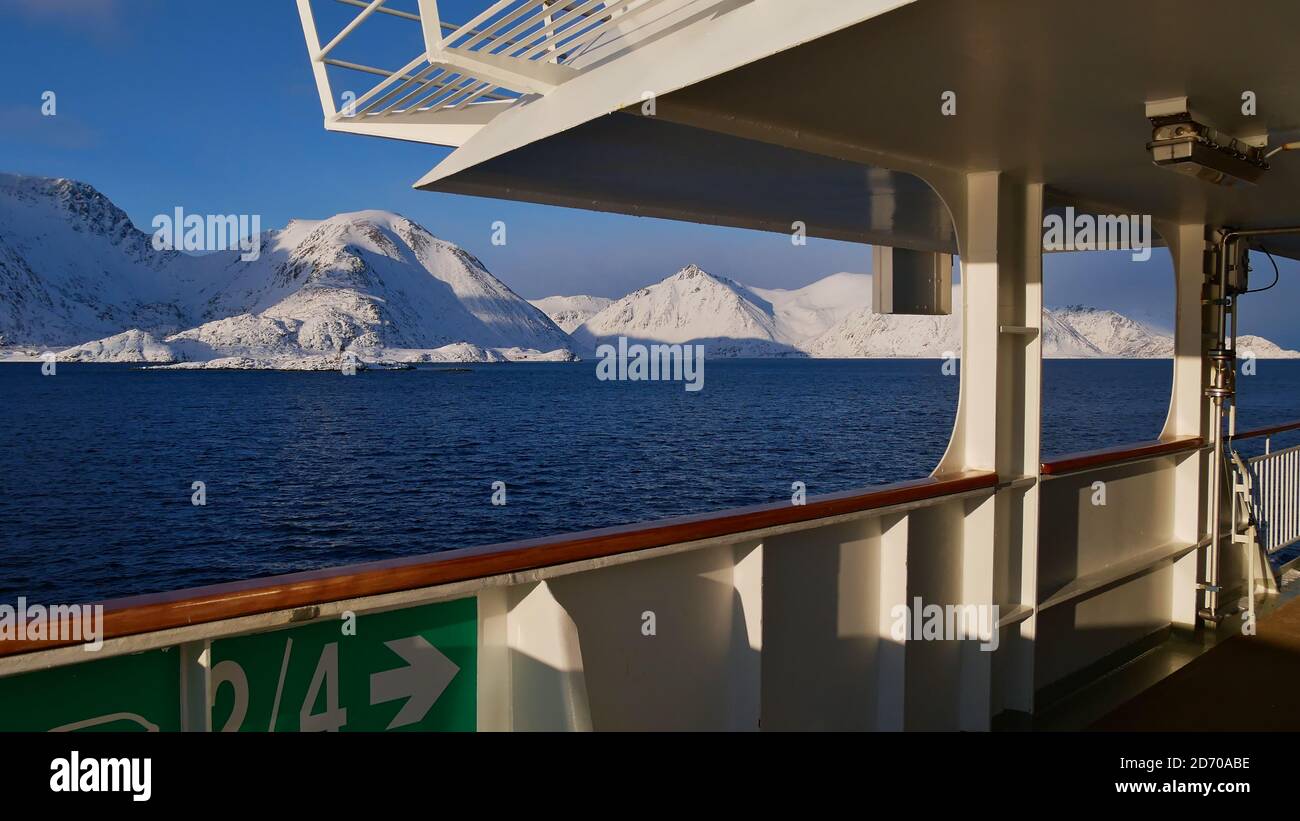 Sørøysundet, Norwegen - 03/02/2019: Schneebedeckte Berge der arktischen Insel Sørøya im Winter vom Deck des Hurtigruten Kreuzfahrtschiffes beobachtet. Stockfoto