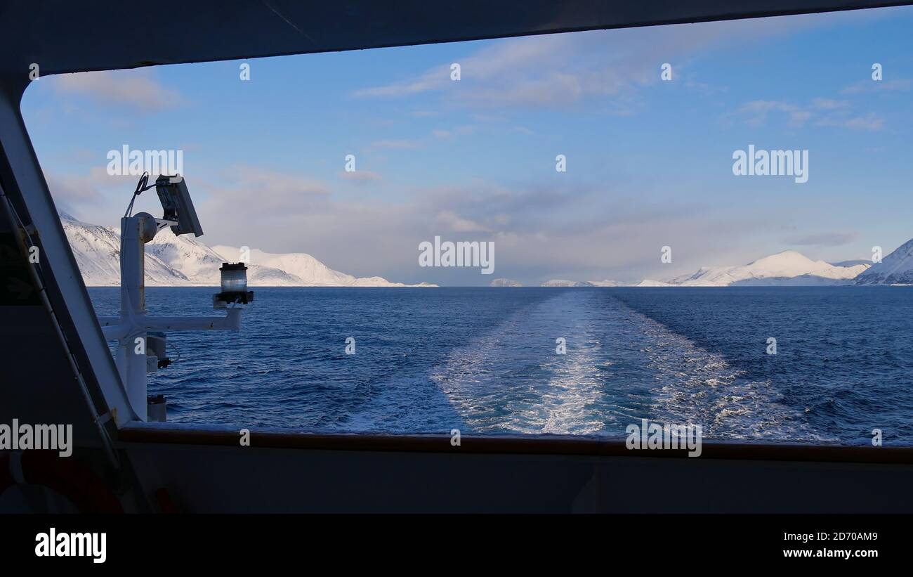 Sørøysundet, Norwegen - 03/02/2019: Blick auf den arktischen Ozean in Nordnorwegen mit schneebedeckten Bergen vom Heck des Hurtigruten Kreuzfahrtschiffes. Stockfoto