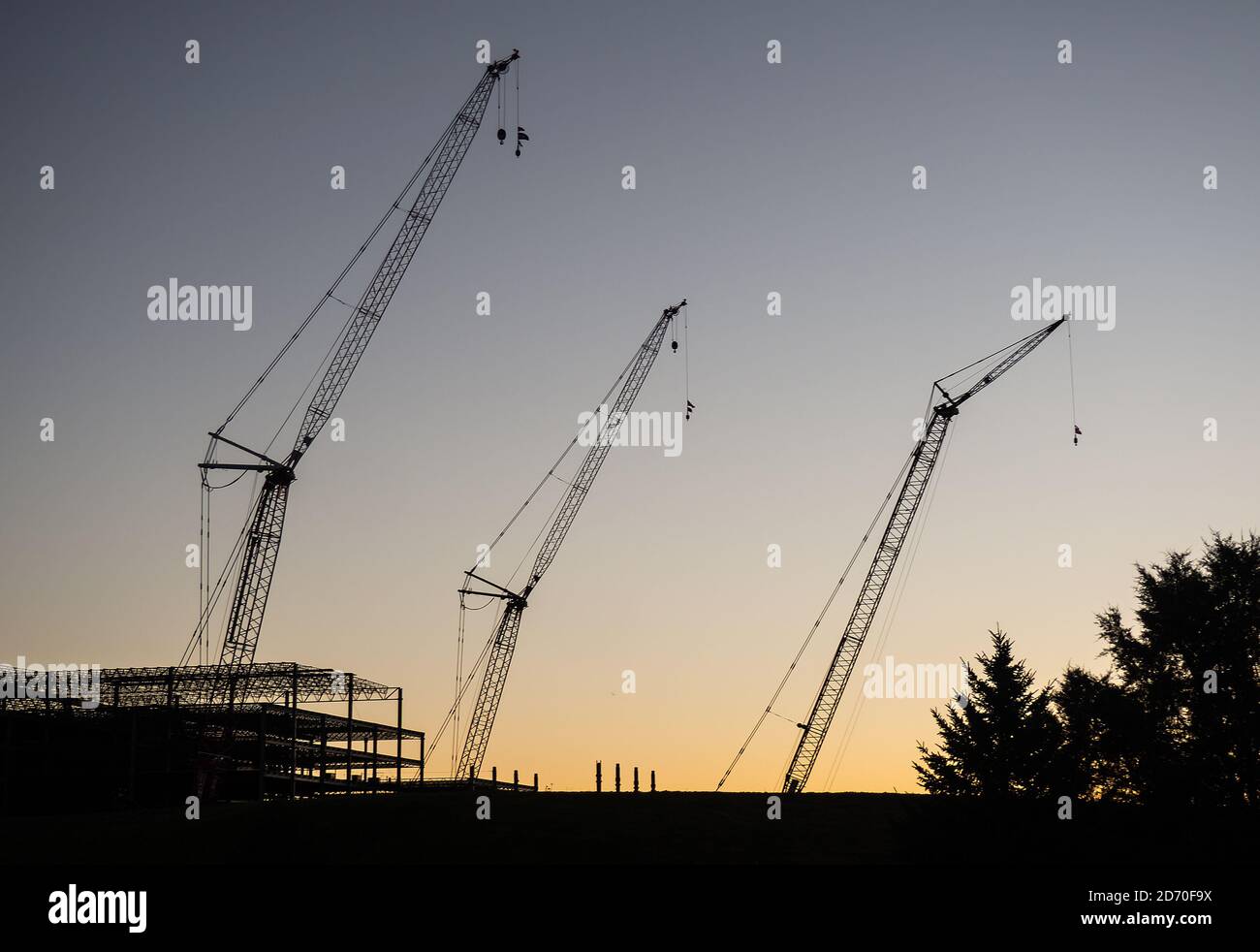 Silhouette von Baukräne auf der Baustelle bei Sonnenaufgang Stockfoto